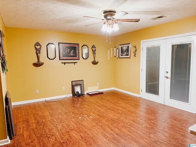 spare room with ceiling fan, french doors, wood-type flooring, and a textured ceiling