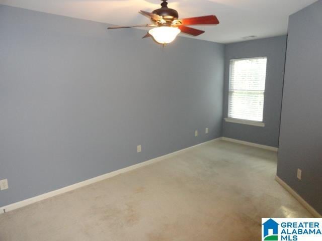 carpeted spare room with ceiling fan