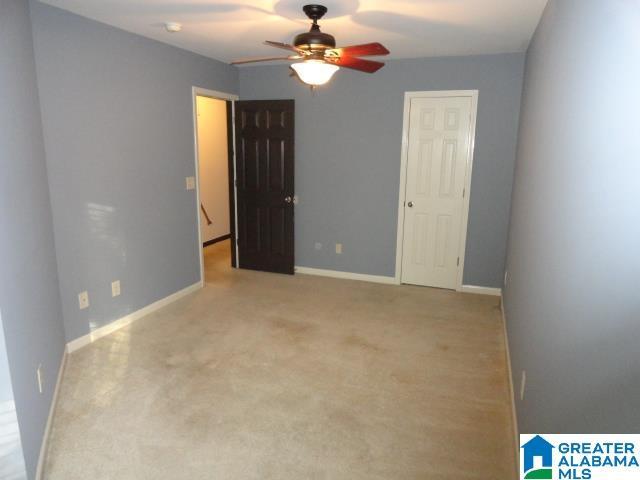 carpeted empty room featuring ceiling fan