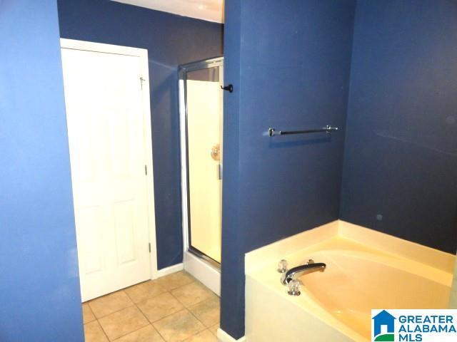 bathroom featuring tile patterned flooring and shower with separate bathtub