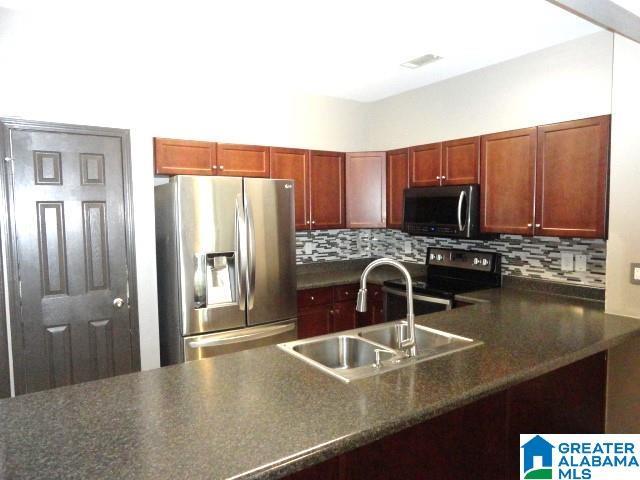 kitchen with decorative backsplash, sink, and stainless steel appliances