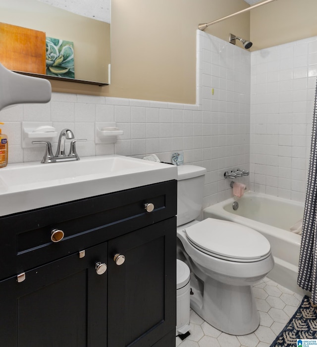 full bathroom with tile patterned floors, vanity, shower / bath combo with shower curtain, tile walls, and toilet