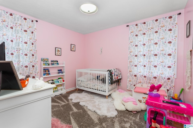 carpeted bedroom with a nursery area