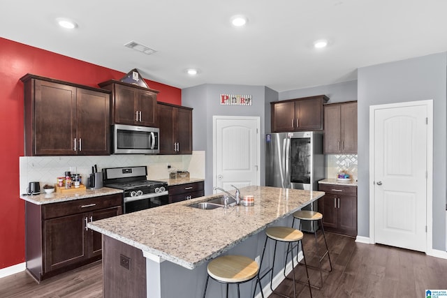 kitchen featuring dark hardwood / wood-style flooring, an island with sink, stainless steel appliances, and sink