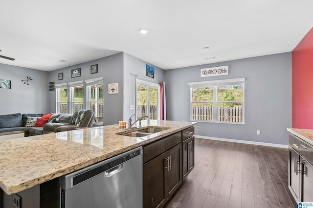 kitchen featuring sink, stainless steel dishwasher, dark hardwood / wood-style floors, a kitchen island with sink, and dark brown cabinets