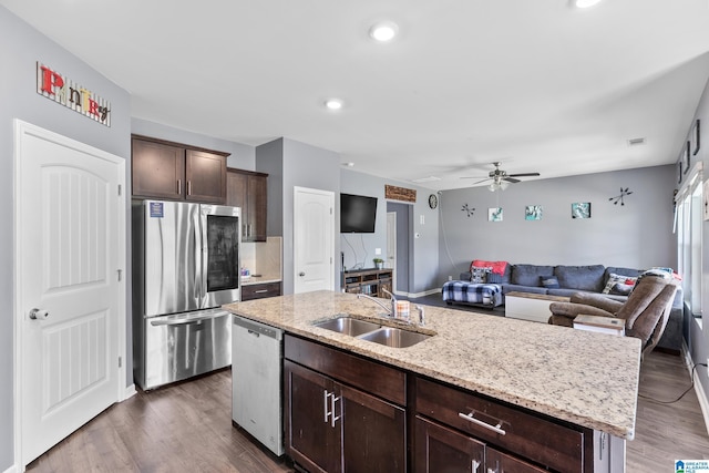 kitchen featuring dark hardwood / wood-style floors, sink, stainless steel appliances, and a kitchen island with sink