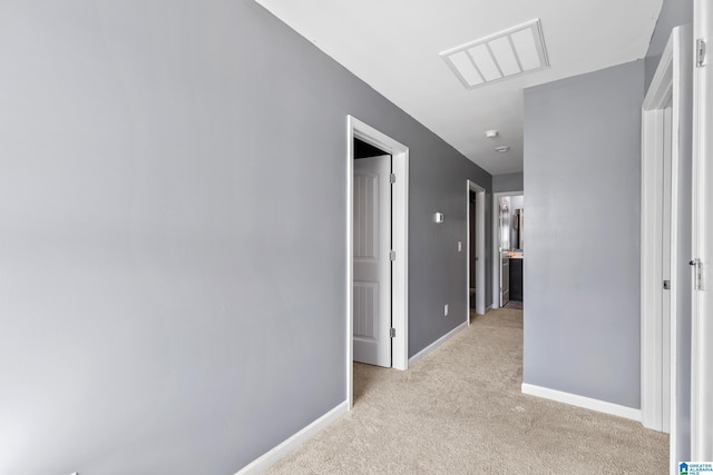 hallway featuring light colored carpet