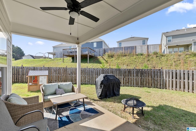 view of patio with grilling area, ceiling fan, and an outdoor living space with a fire pit