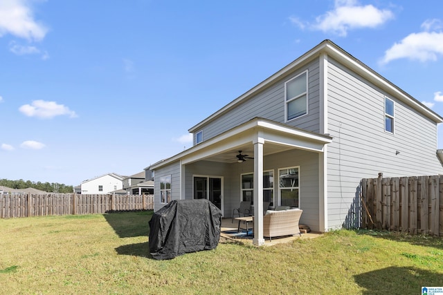 back of property featuring ceiling fan, a yard, and an outdoor living space