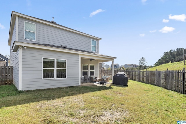 rear view of house with a patio area, ceiling fan, and a yard