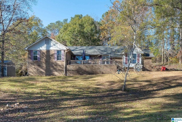 rear view of property with a lawn and a deck