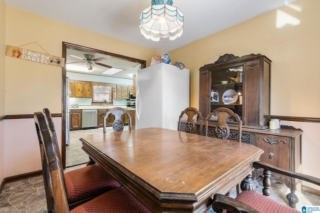 dining area with ceiling fan and sink