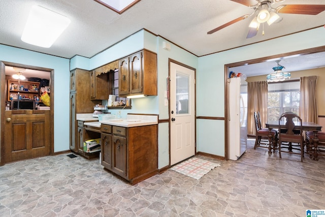 kitchen featuring ceiling fan and a textured ceiling