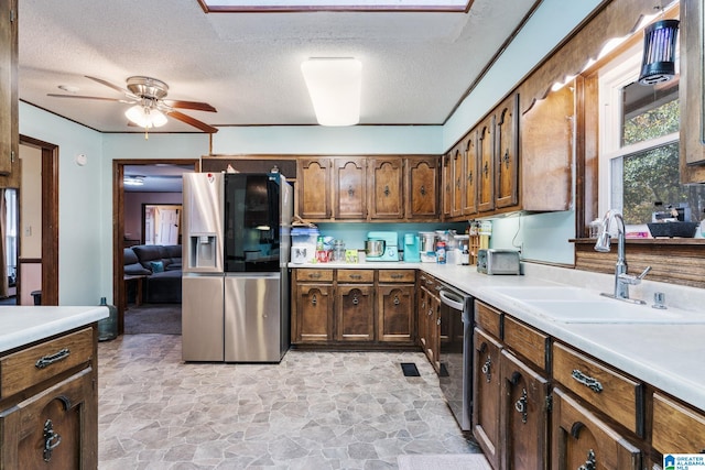 kitchen with ceiling fan, sink, stainless steel appliances, and a textured ceiling