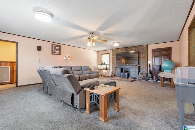 living room featuring carpet flooring, a textured ceiling, a wood stove, and ceiling fan