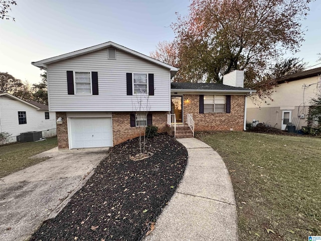 split level home featuring a garage, central air condition unit, and a front lawn