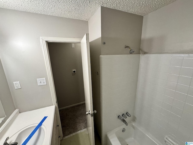 bathroom with vanity, a textured ceiling, and washtub / shower combination