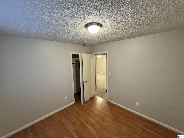 unfurnished bedroom featuring a textured ceiling and hardwood / wood-style flooring