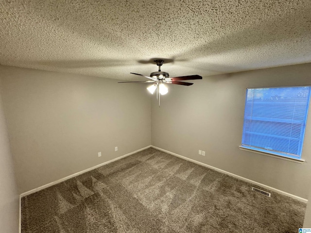 empty room with carpet flooring, ceiling fan, and a textured ceiling