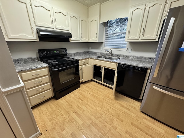 kitchen with a textured ceiling, sink, light hardwood / wood-style flooring, and black appliances