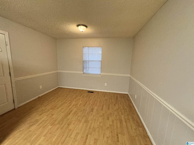 empty room featuring hardwood / wood-style floors and a textured ceiling