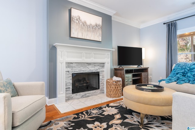 living room with light hardwood / wood-style floors, ornamental molding, and a fireplace