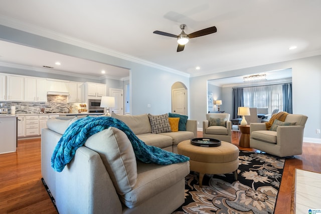 living room featuring light hardwood / wood-style floors, ceiling fan, and ornamental molding