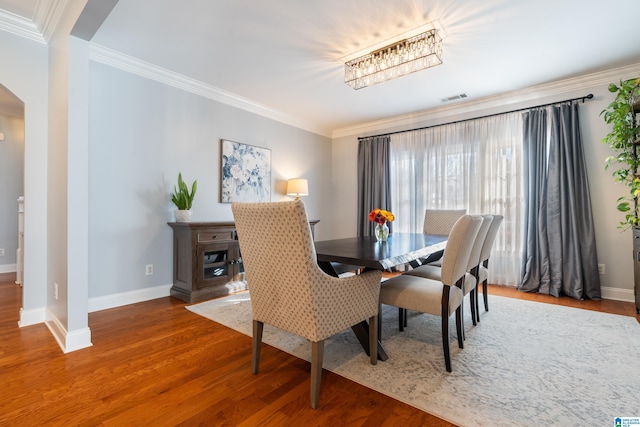 dining area featuring crown molding and wood-type flooring