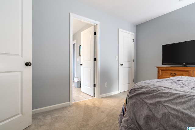 bedroom featuring light carpet and connected bathroom