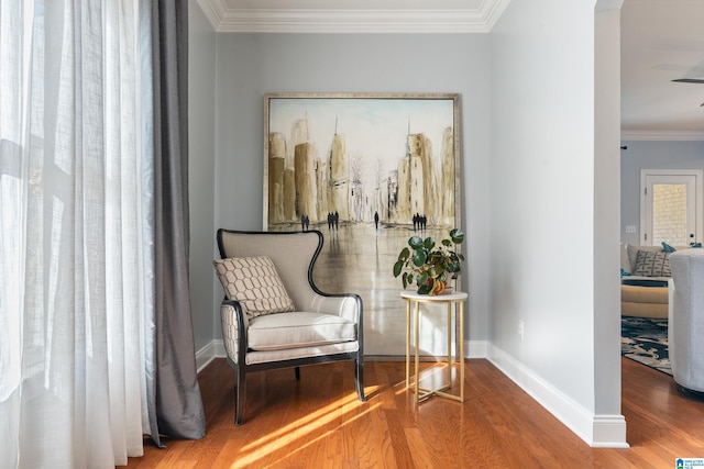 sitting room featuring wood-type flooring and crown molding