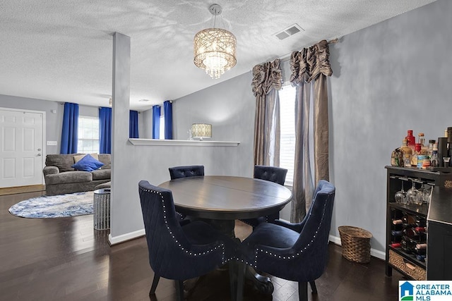 dining room featuring a chandelier, a textured ceiling, and hardwood / wood-style flooring