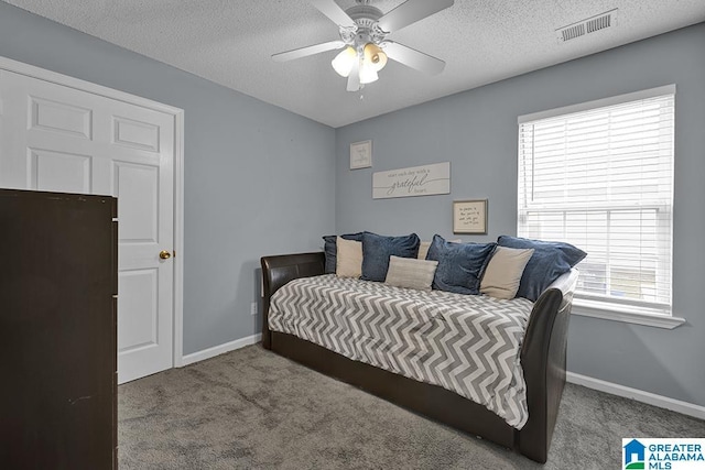 carpeted bedroom featuring a textured ceiling and ceiling fan