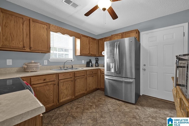 kitchen with ceiling fan, sink, stainless steel appliances, tile patterned flooring, and a textured ceiling