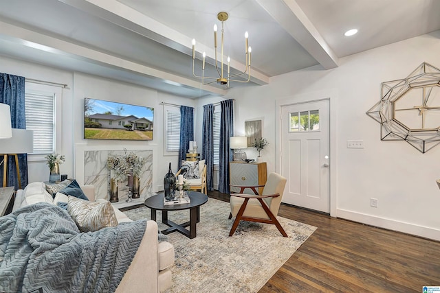 living room featuring beamed ceiling, dark hardwood / wood-style flooring, and a notable chandelier