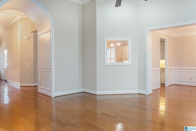 spare room with hardwood / wood-style flooring, ceiling fan, and crown molding