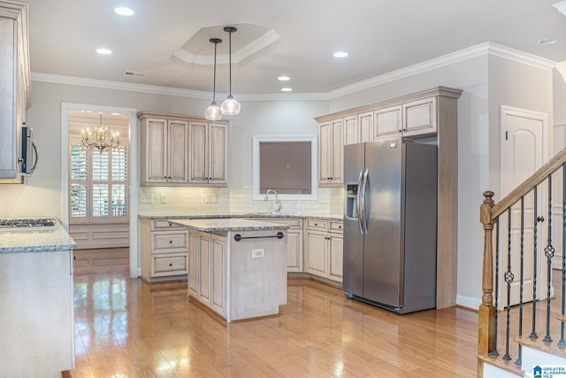 kitchen featuring a center island, ornamental molding, appliances with stainless steel finishes, and light hardwood / wood-style flooring