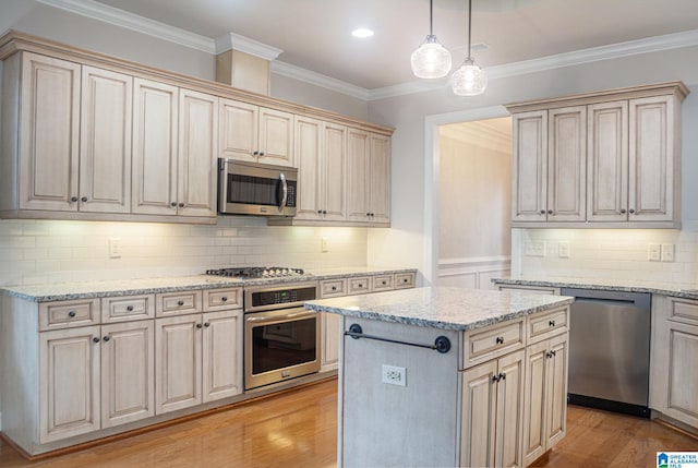 kitchen with a center island, stainless steel appliances, crown molding, decorative light fixtures, and light wood-type flooring