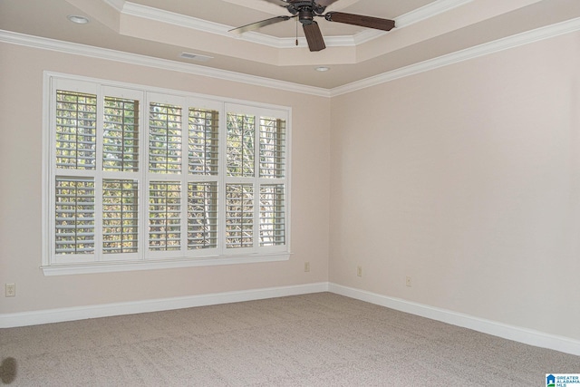 spare room featuring carpet flooring, ornamental molding, a wealth of natural light, and a tray ceiling