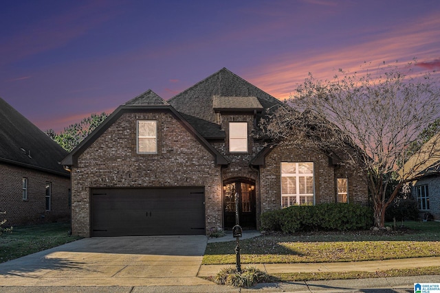 view of front of house featuring a garage and a yard