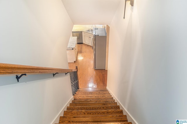 stairway with hardwood / wood-style floors and sink