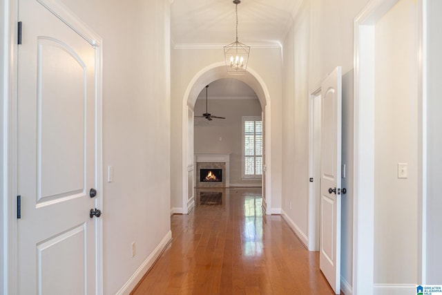 corridor with wood-type flooring and crown molding