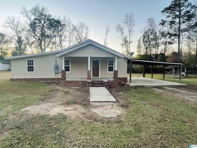 view of front of property with a lawn, covered porch, and a carport