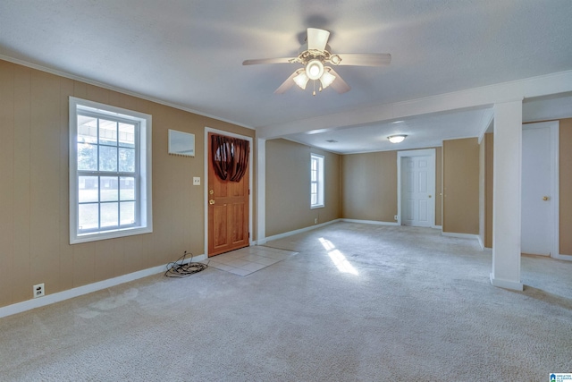 carpeted entrance foyer featuring ceiling fan and ornamental molding