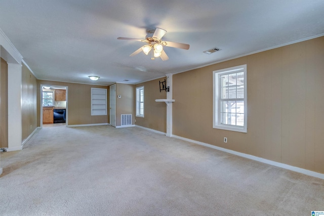 carpeted empty room with ceiling fan and crown molding