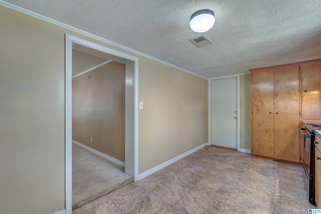 interior space featuring a textured ceiling, a closet, and crown molding