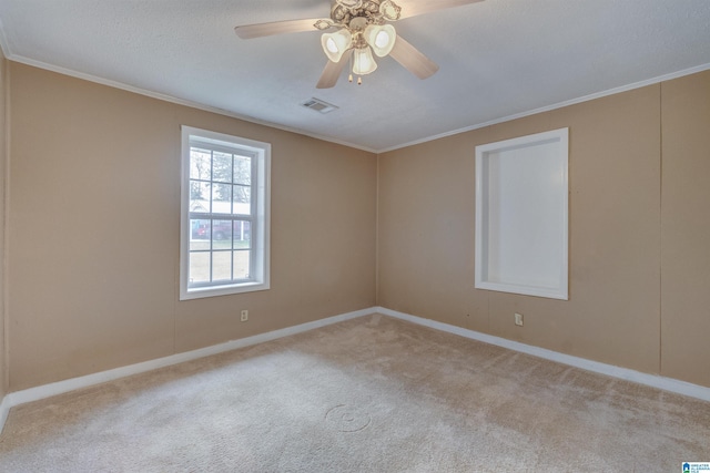 empty room with ceiling fan, crown molding, and light carpet