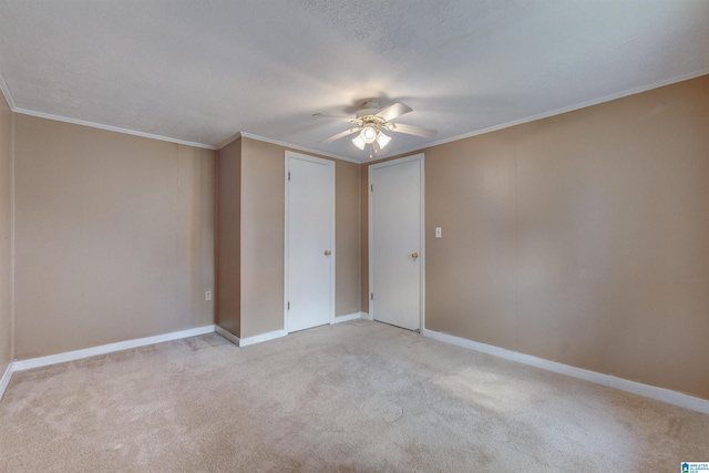 spare room featuring ceiling fan, crown molding, and light carpet