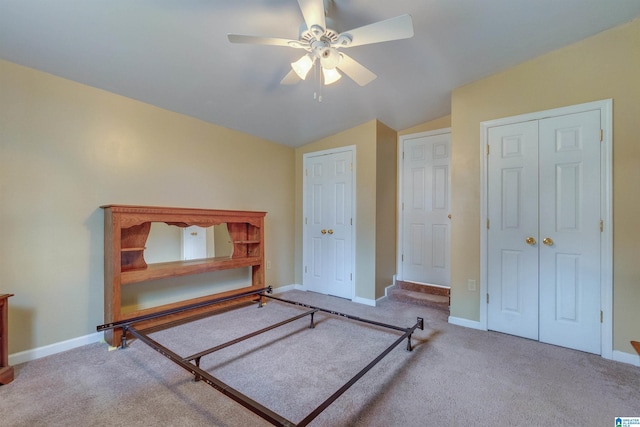 carpeted bedroom with vaulted ceiling and ceiling fan