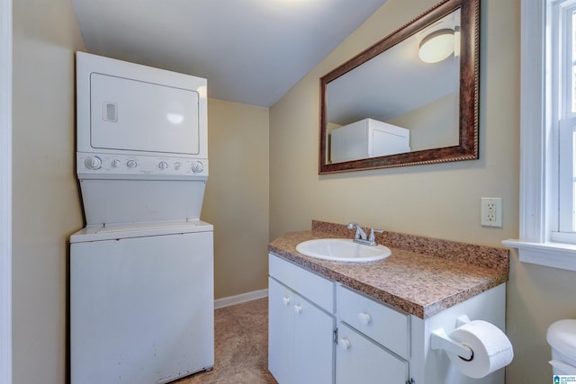 bathroom with vanity, stacked washing maching and dryer, and lofted ceiling