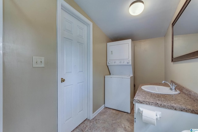 washroom featuring stacked washing maching and dryer and sink